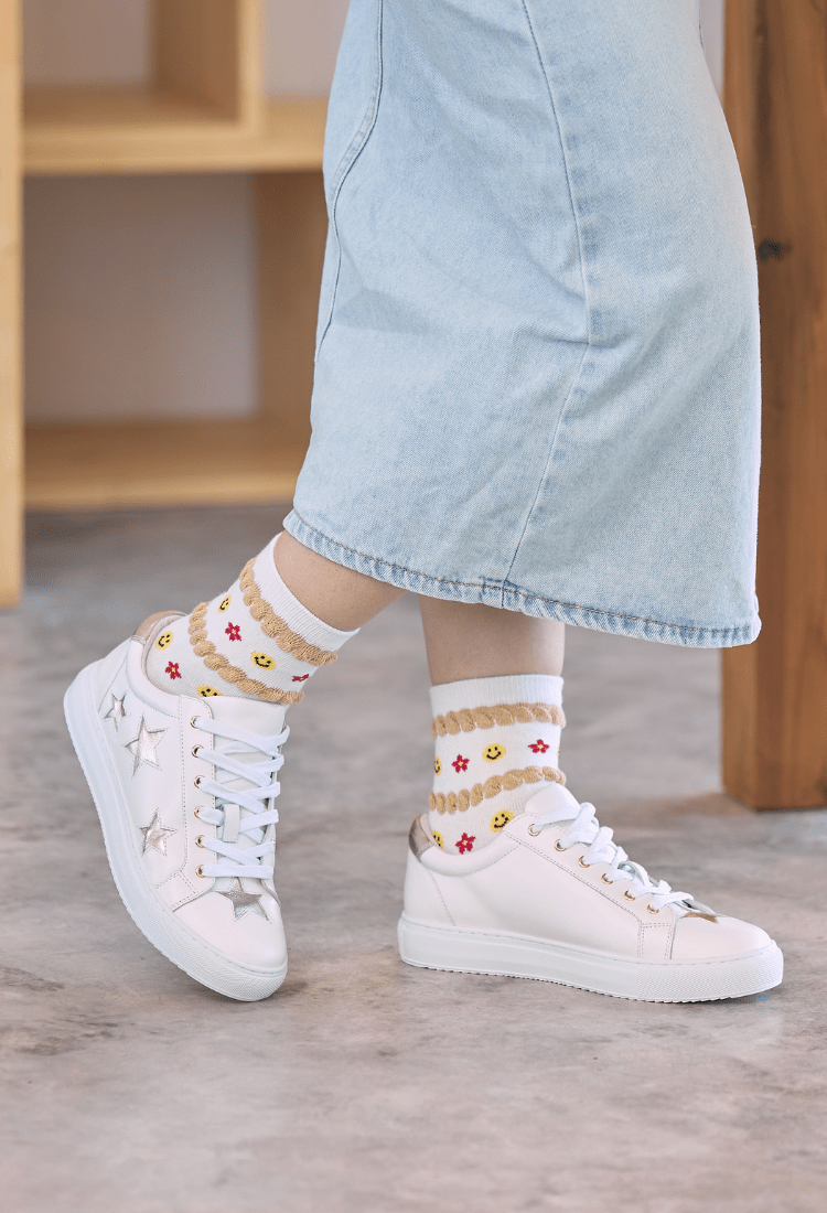 Lady wearing trainers with light denim skirt