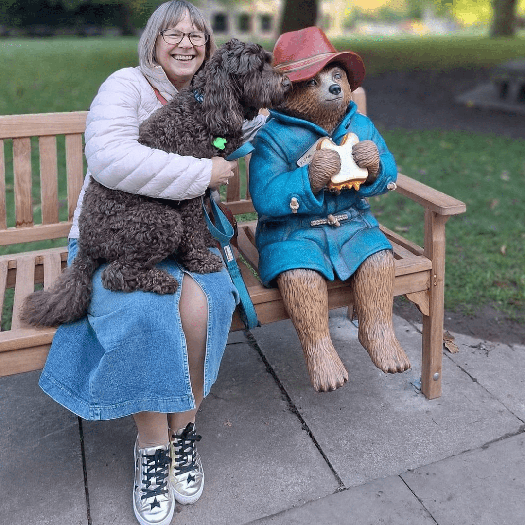 woman wearing gold trainers with black stars on park bench with dog, casual everyday look