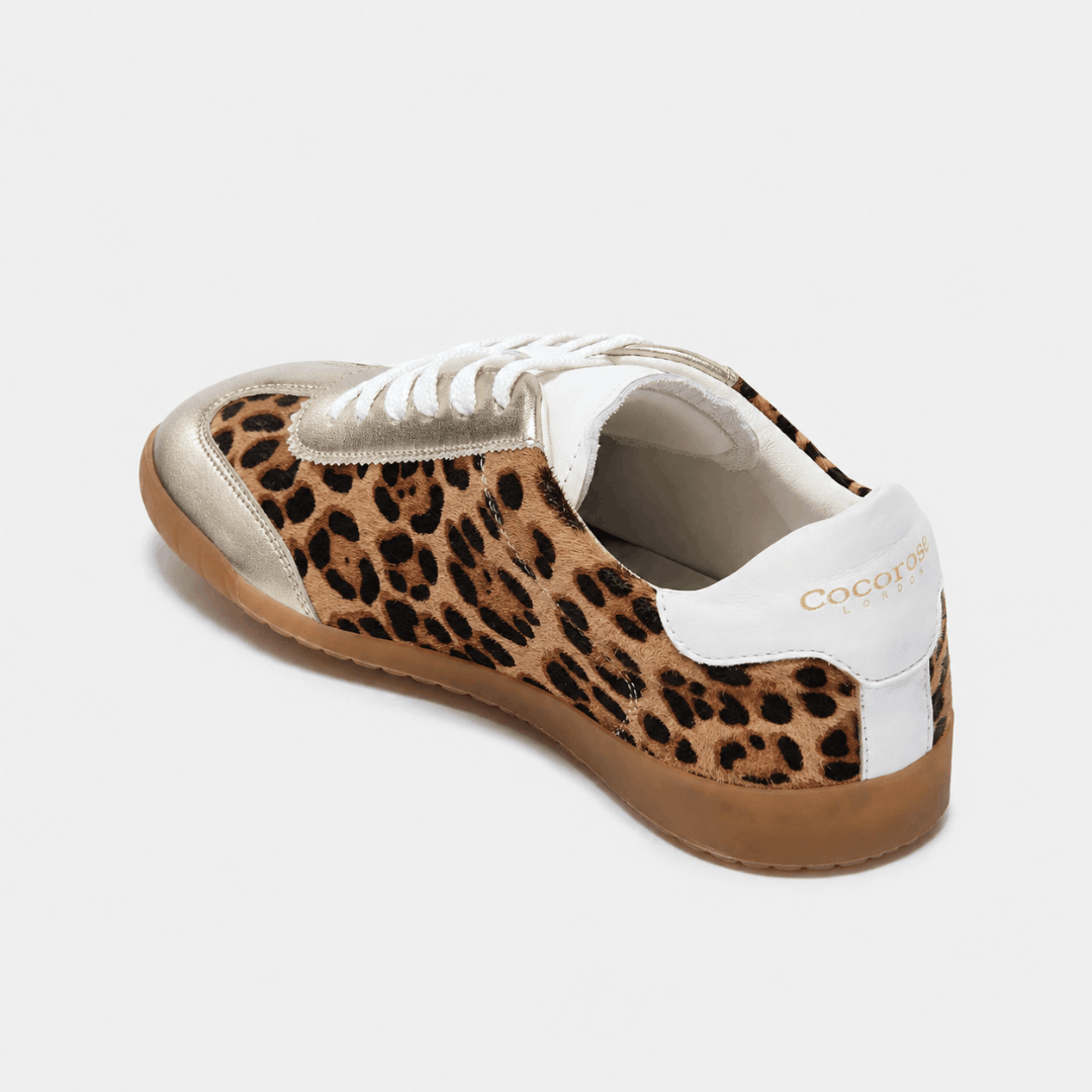 An angled rear view of a Moorgate leopard print sneaker with metallic gold trim and a white heel tab featuring the Cocorose London logo.