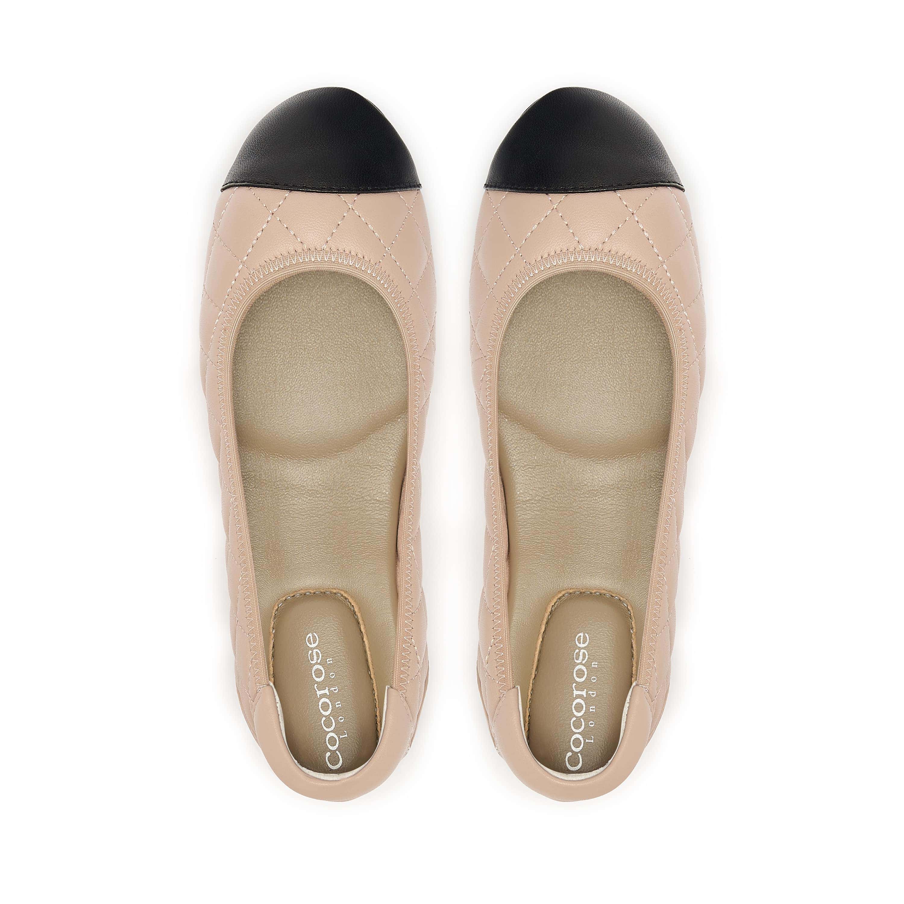 Quilted leather ballet flat in nude with black toe cap, birds eye view