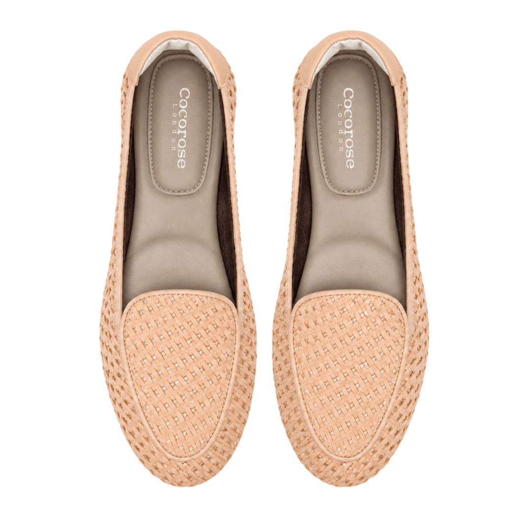 A top-down, bird's-eye view of a pair of beige woven loafers featuring "Cocorose London" branding on the insoles, isolated on a white background.