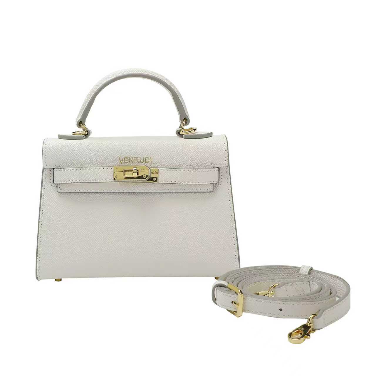 White handbag with gold accents and a detachable strap on a white background
